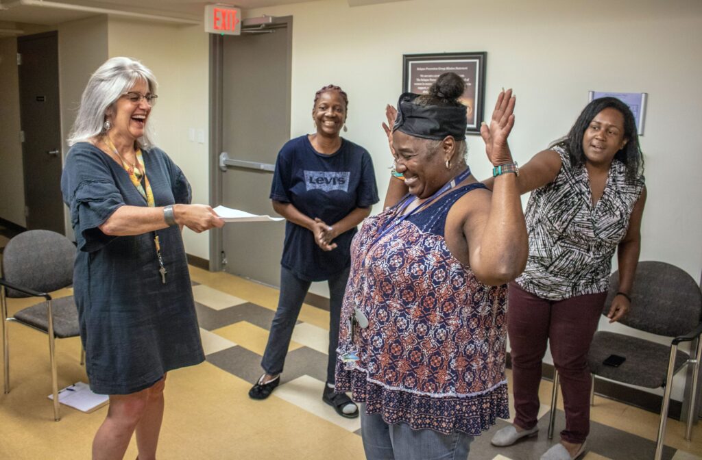 A group of four women laughing while taking an improv class